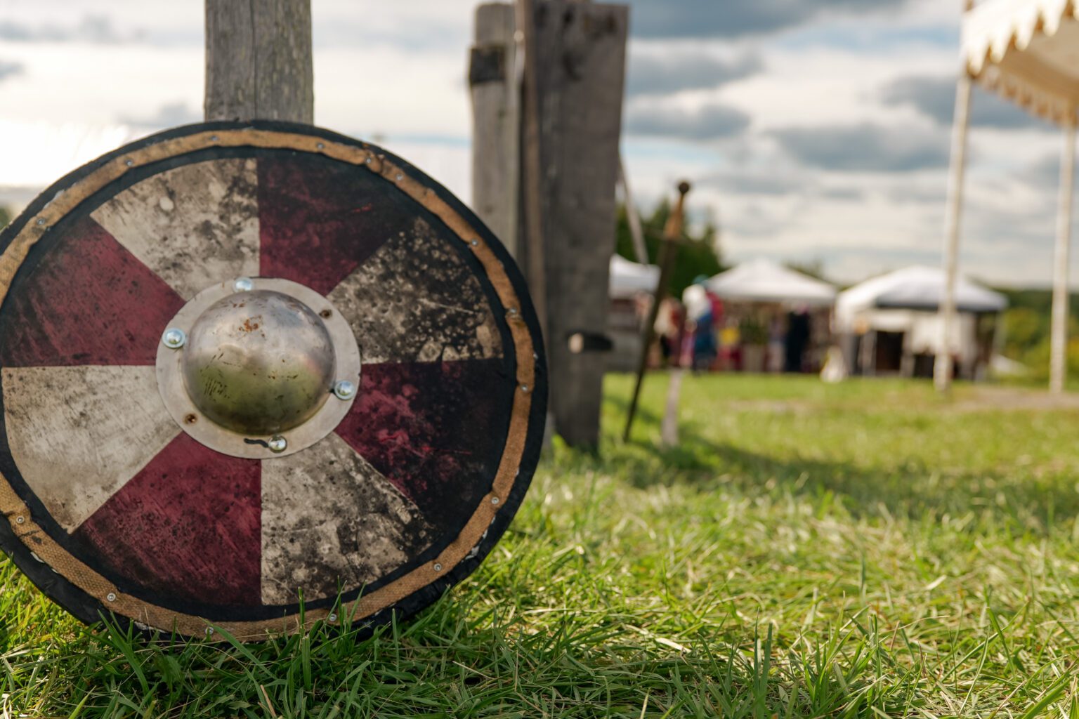 A shield leans against a post at a medieval fair
